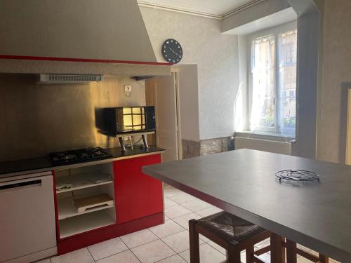- une cuisine avec un comptoir, une table et une cuisinière dans l'établissement giteMANU, à Arbois