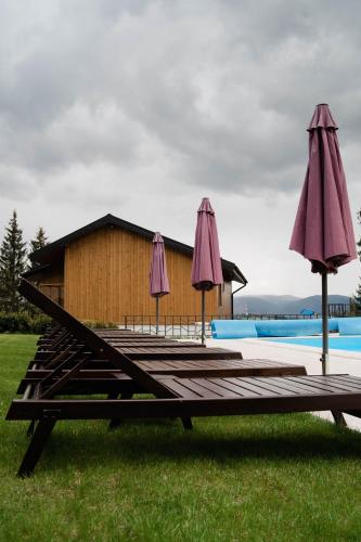 a group of umbrellas sitting on a wooden deck at Gogodz Chalet Resort in Yablunytsya