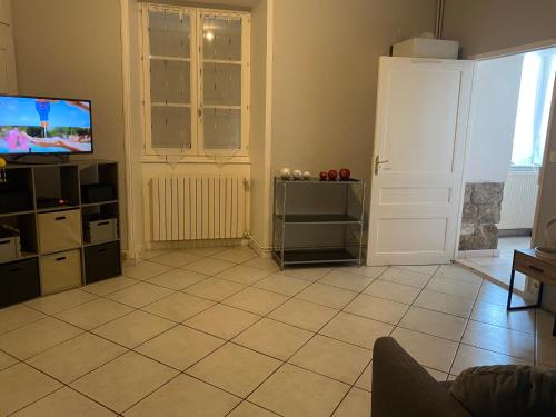 Il comprend un salon doté d'une télévision et de carrelage. dans l'établissement giteMANU, à Arbois