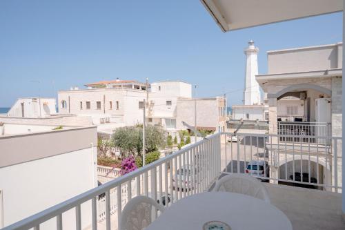 a balcony with a table and chairs and a lighthouse at Morfeo in Torre Canne