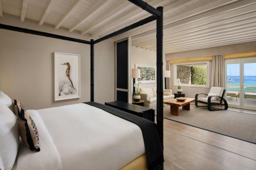 a bedroom with a bed and a living room at Santa Marina, A Luxury Collection Resort, Mykonos in Ornos