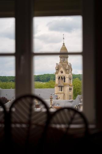 a view of a clock tower from a window at Jungle Évasion, Épernay in Épernay