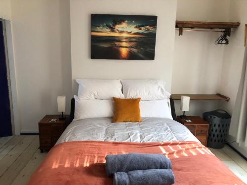 a bedroom with a bed with orange and white pillows at Stylish flat in Chesterfield near Peak District in Chesterfield