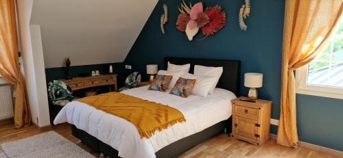 a bedroom with a bed with a blue wall at Les Randonneuses in Marcilly-sur-Seine