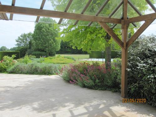 a pergola in a garden with flowers at Les Randonneuses in Marcilly-sur-Seine