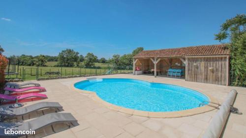 a swimming pool in a yard with chairs and a building at Gîtes la Bonninière rose in Neuvy-Bouin
