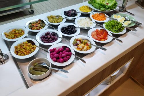 a buffet with many bowls of different types of food at El Aziz Inn in Cheraga