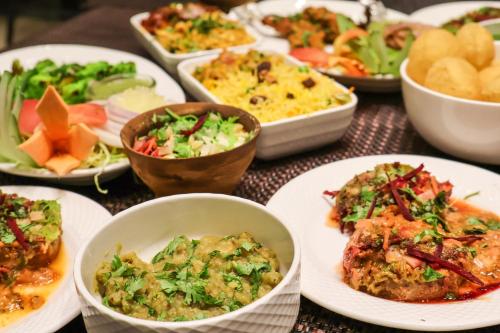 una mesa con platos de comida y tazones de comida en HHW Buddha Lineage, en Varanasi
