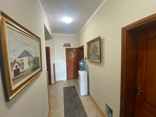a hallway with a painting on the wall and a refrigerator at Vila Madams - Palić-Serbia in Palić
