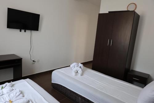 a hotel room with two beds and a cabinet at Hotel Lobo Budva in Budva