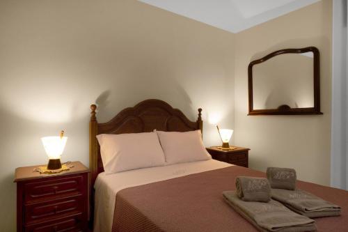 a bedroom with a bed with two lamps and a mirror at Vintage Copio Apartment in Vila Nova de Gaia