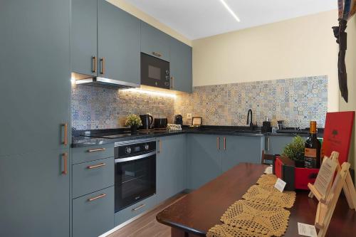 a kitchen with blue cabinets and a wooden table at Vintage Copio Apartment in Vila Nova de Gaia