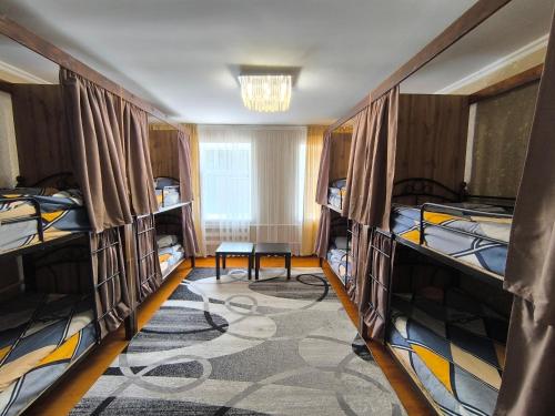 a room with three bunk beds and a table in it at Hostel Nice in Karakol