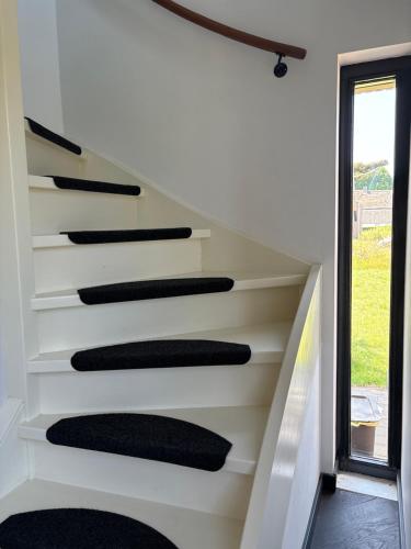 a set of stairs in a room with a window at Casita Wijchen complete Tiny house in Wijchen