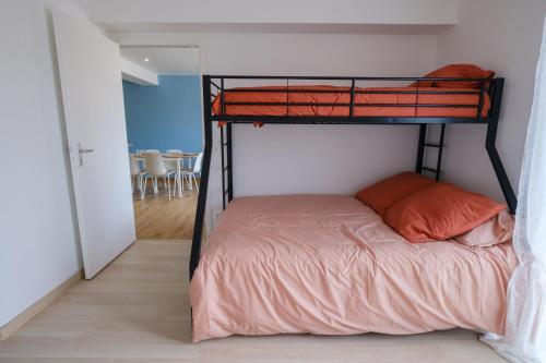 - une chambre avec des lits superposés et un oreiller orange dans l'établissement Appartement neuf proche mer, à Jullouville