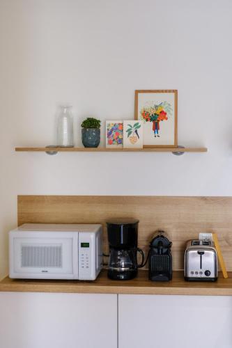 une étagère de cuisine avec un four micro-ondes et une cafetière dans l'établissement Appartement neuf proche mer, à Jullouville