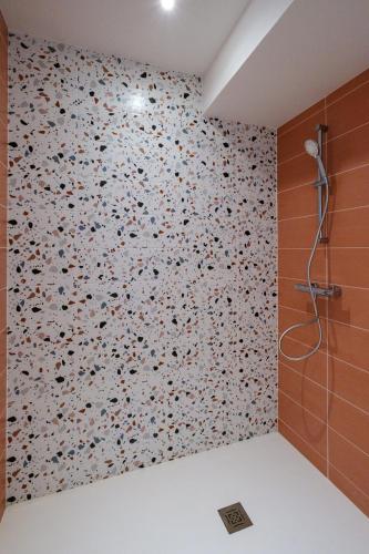 La salle de bains est pourvue d'un mur recouvert de fleurs. dans l'établissement Appartement neuf proche mer, à Jullouville