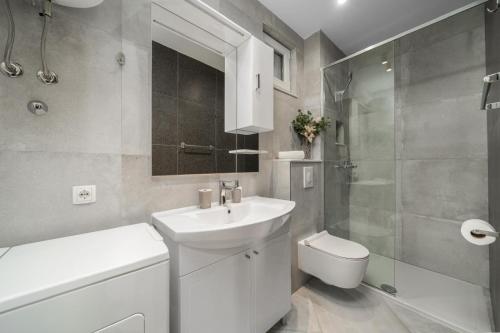 a white bathroom with a sink and a toilet at Apartmani Miranda in Drasnice