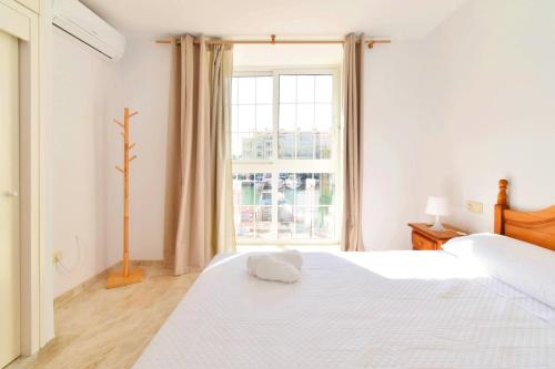a white bedroom with two beds and a window at Expoholidays - Centro Almerimar Puerto Deportivo in Almerimar