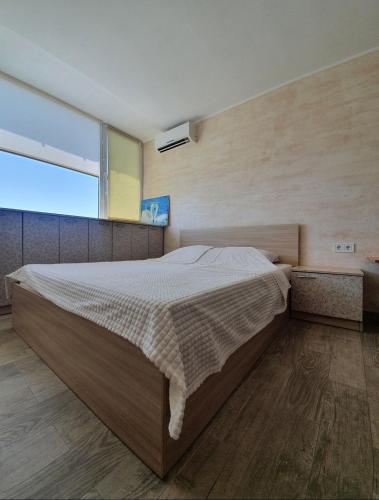 a bedroom with a large bed and a large window at Light room Затока in Zatoka