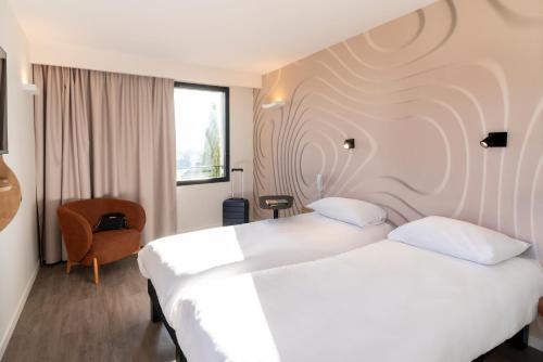 a hotel room with two beds and a chair at ibis Styles Cabriès Aix-en-Provence TGV in Cabriès