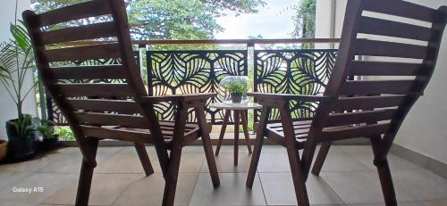 Una mesa y dos sillas en un balcón. en Khaya Apartments Victoria Falls Estate, en Victoria Falls