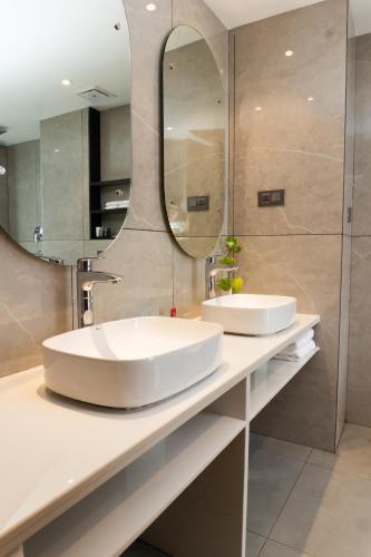 a bathroom with two sinks and a large mirror at Lumbini Green Resort, Chandrauta in Bhagwanpur