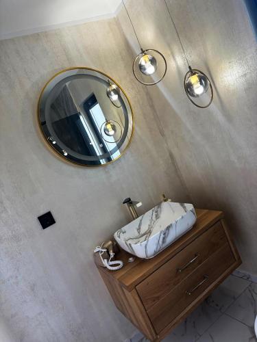 a bathroom with a sink and a mirror at Cuibul lui Răzvan - Domeniul Barabuc Colibița in Colibiţa
