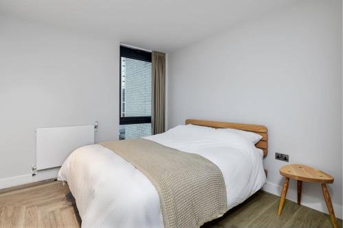 a white bedroom with a bed and a window at Alameda and Beton in London near Wembley Park in London