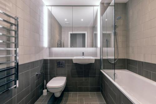 a bathroom with a toilet and a sink and a bath tub at Alameda and Beton in London near Wembley Park in London