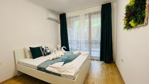 a bed in a room with a large window at ASTORIA II Apartment 12 Sveti Vlas in Elenite