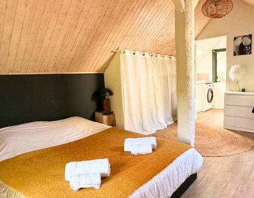 une chambre avec un grand lit avec des serviettes dessus dans l'établissement Villa des Etoiles - Un Hâvre de Paix avec Piscine, à Brive-la-Gaillarde