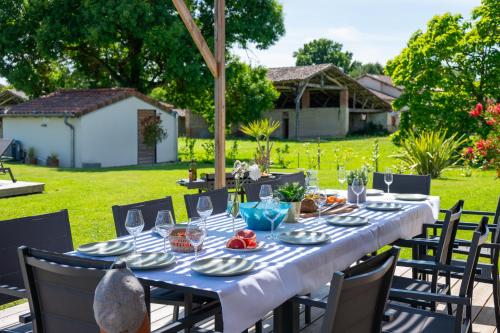 a table with plates and glasses on top of a yard at La Villa face au Lac in Saramon