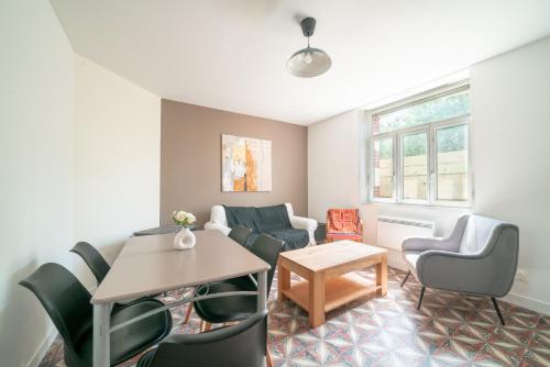 un salon avec une table et des chaises dans l'établissement La Brise de Mer - 10min de la Plage, à Les Moitiers-dʼAllonne