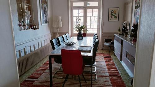 une salle à manger avec une table et des chaises rouges dans l'établissement VILLA 5 CHAMBRES 10 PERSONNES 300m PLAGE DEMOISELLE, à Saint-Jean-de-Monts