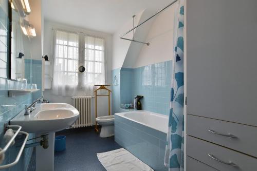 une salle de bain avec un lavabo, une baignoire et des toilettes dans l'établissement La Chevrière - Grande maison à 50m de la plage, à Saint-Cast-le-Guildo