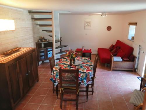 un salon avec une table et un canapé rouge dans l'établissement Gîte du Moulin de Brendouez, à Guissény
