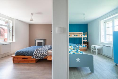 a bedroom with blue walls and a bed in it at Le Logis d'Allonne - 10min de la Plage in Les Moitiers-dʼAllonne