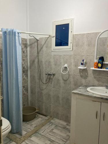 a bathroom with a shower and a toilet and a sink at Maison salakta plage in Ksour Essaf