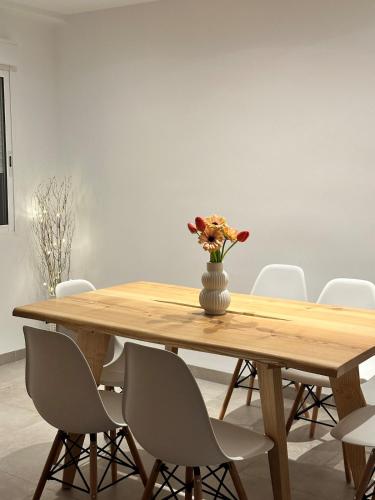 a wooden table with a vase of flowers on it at Abadesa Apartments in Benetúser