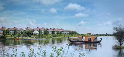 a boat on a river with buildings in the background at MAYFAIR Lake Resort in Raipur