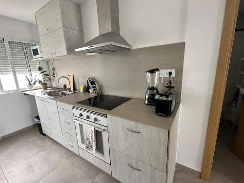a kitchen with a sink and a stove top oven at Abadesa Apartments in Benetúser