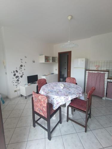 a table and chairs in a room with a kitchen at Simone 2C in Marcelli di Numana