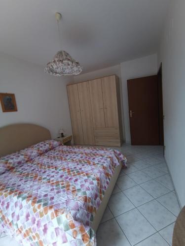 a bedroom with a bed and a chandelier at Simone 2C in Marcelli di Numana