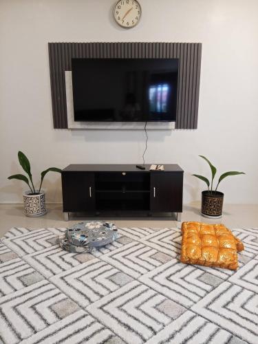 a living room with a flat screen tv on a wall at Affordable Room with Full Kitchen in Calamba in Bukal