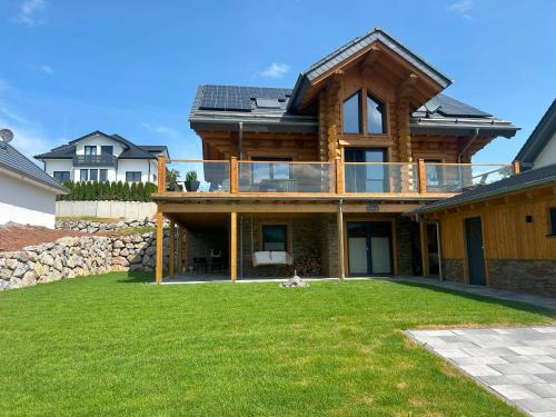 a house with a large yard in front of it at Ferienwohnung Uplandblockhaus in Willingen