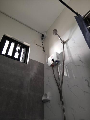 a bathroom with a shower with a blow dryer at Affordable Room with Full Kitchen in Calamba in Bukal