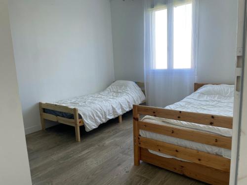 une chambre avec deux lits et une fenêtre dans l'établissement ღ L'Andillys - Maison Spacieuse, Jardin & Wifi, à La Celle-sous-Gouzon