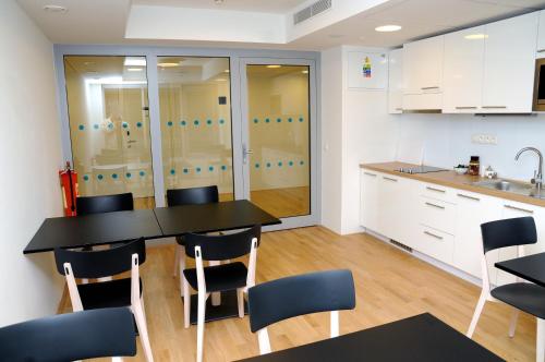 a kitchen with white cabinets and a black table and chairs at Hotel Erwin Junker in Holice