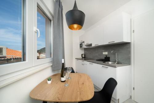 a kitchen with a wooden table and a window at Apartmani Miranda in Drasnice